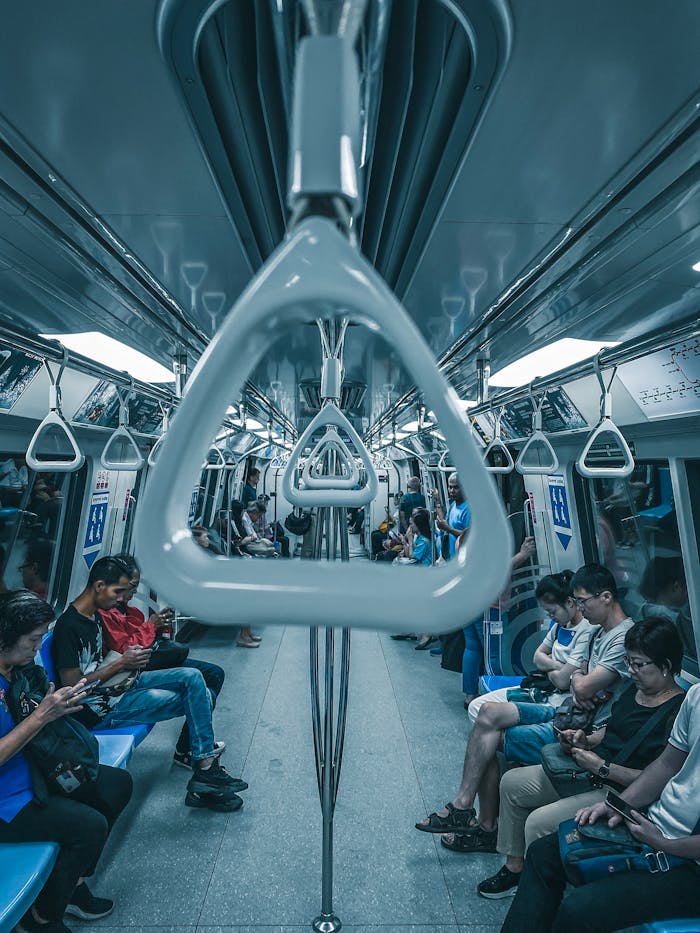 Passengers on a subway train engaged with their phones, emphasizing urban travel.